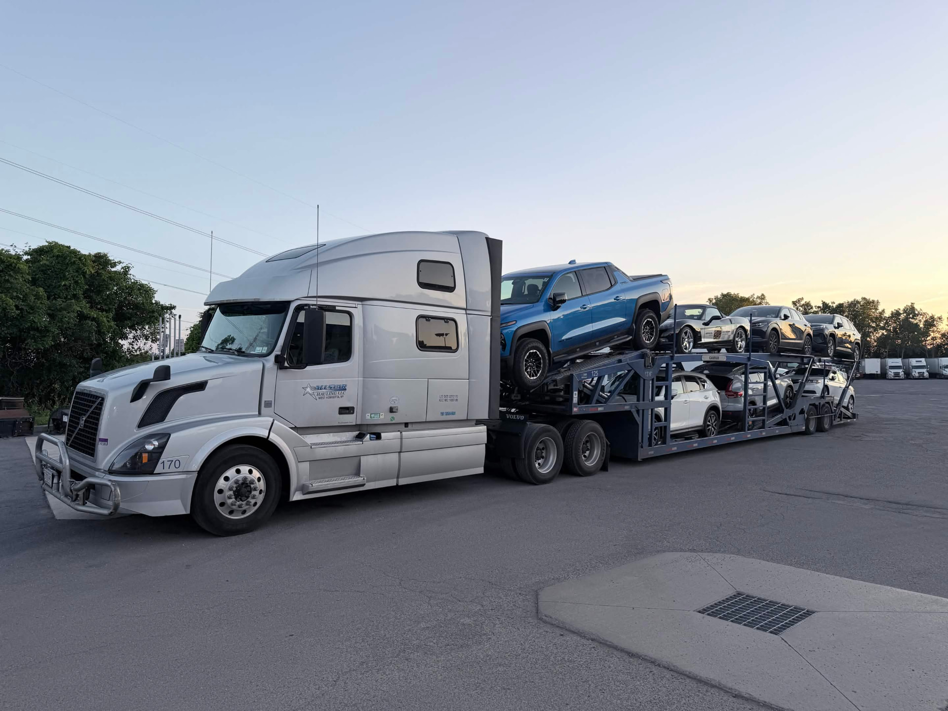 Allstar Hauling Volvo car carrier loaded with new trucks and SUVs at sunset