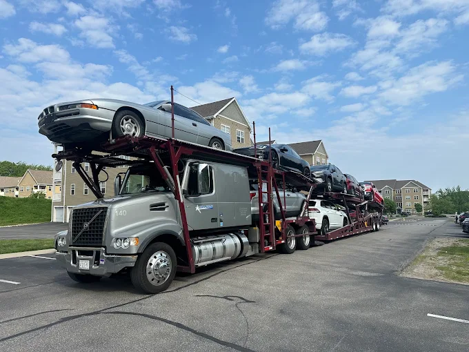 Allstar Hauling Volvo VHD nine-car hauler loaded with sedans and SUVs in a residential neighborhood