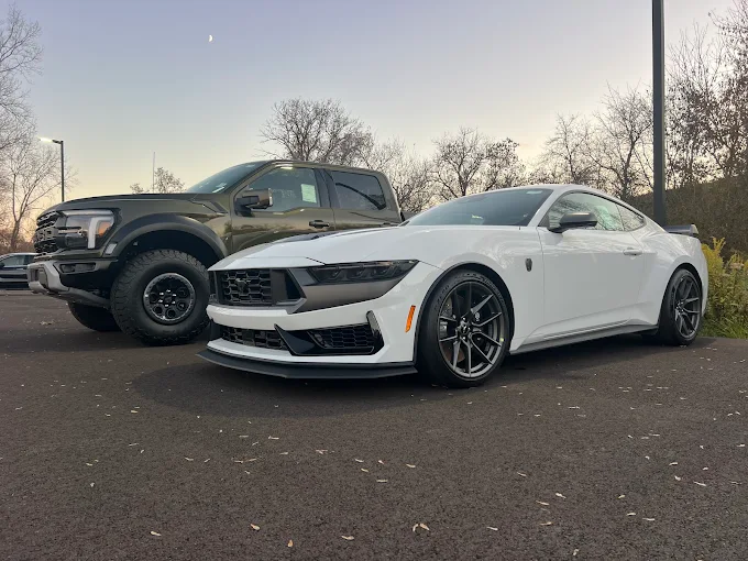 White Ford Mustang Dark Horse and green Ford F-150 Raptor delivered by Allstar Hauling to a private collector