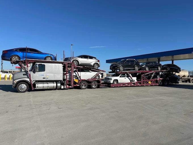 Allstar Hauling car carrier loaded with SUVs and sedans staged at a fuel stop on a Florida-bound run