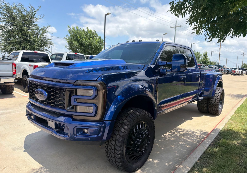 Blue lifted Ford F-450 Platinum dually truck hauled by Allstar Hauling