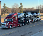 Red Allstar Hauling Volvo eight-car hauler fully loaded at golden hour